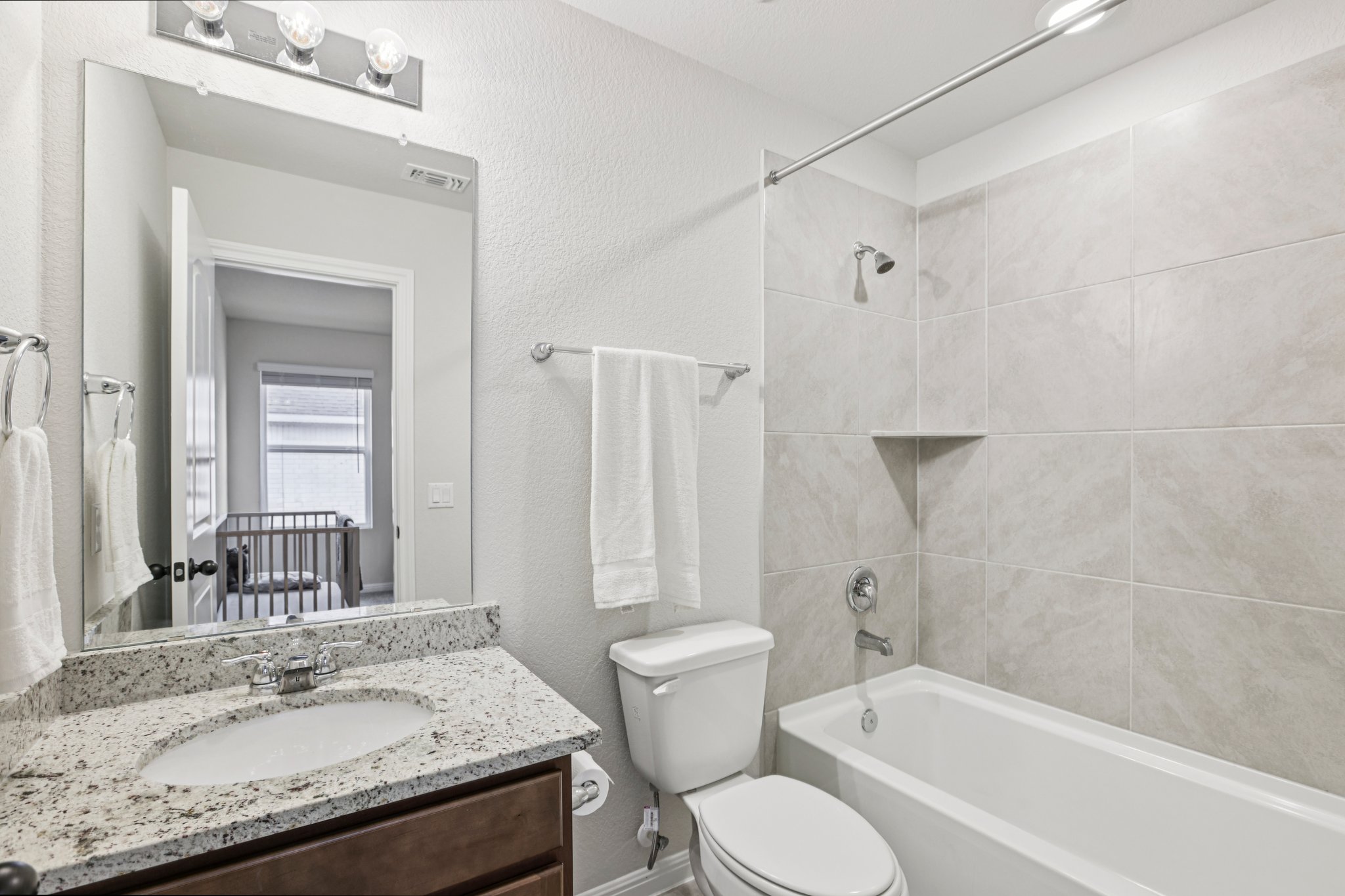 204 Swinging H Lane Georgetown, TX 78633 - Photo 26 of 39 Bathroom featuring a vanity with a light-colored speckled countertop, a built-in sink, and a framed mirror above
