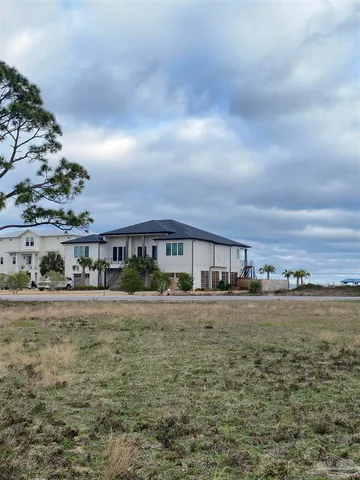 a view of a big house with a big yard and large trees