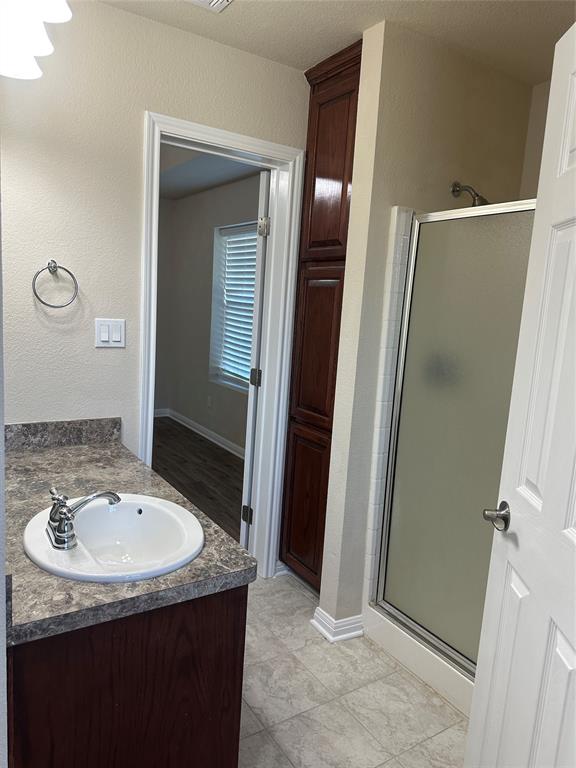 208 Pearl Drive Hewitt, TX 76643 - Photo 11 of 17 Bathroom with vanity, a stall shower, and a textured wall