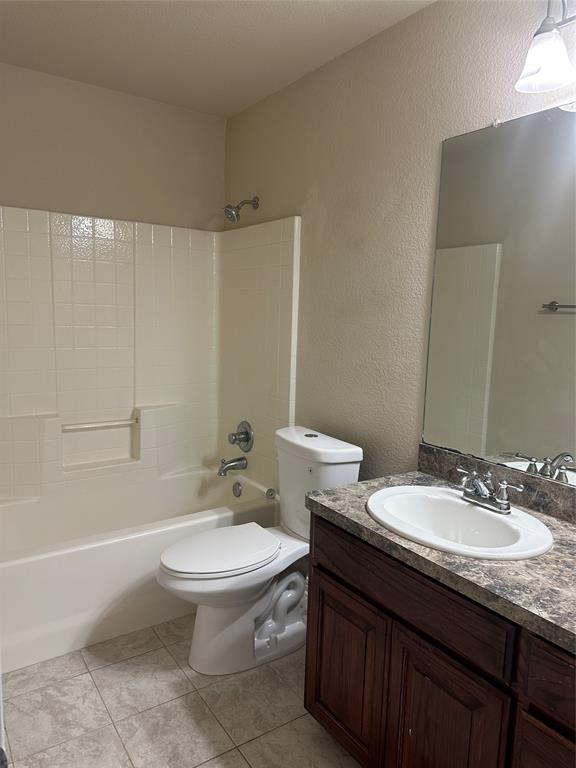 208 Pearl Drive Hewitt, TX 76643 - Photo 14 of 17 Bathroom with a textured wall, vanity, bathtub / shower combination, and light tile patterned floors