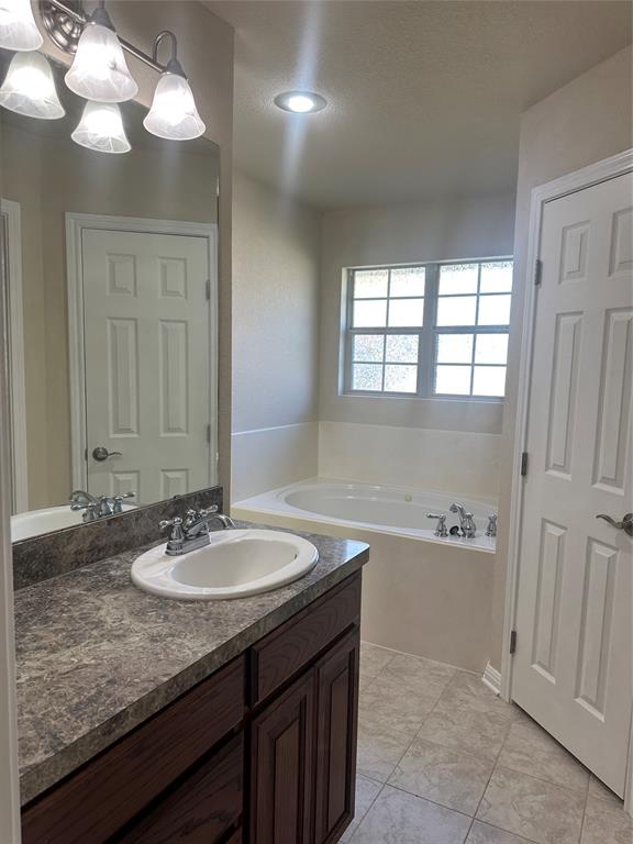 208 Pearl Drive Hewitt, TX 76643 - Photo 10 of 17 Full bathroom featuring vanity, a bath, and light tile patterned floors
