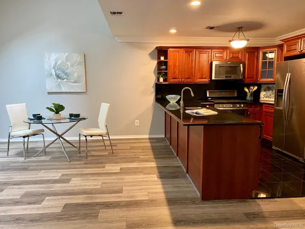 a view of kitchen island wooden cabinets and living room