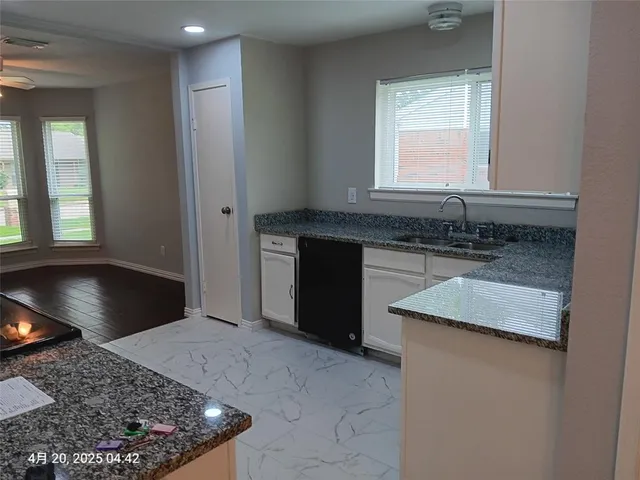 a kitchen with a sink cabinets and a window