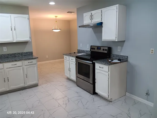 a kitchen with white cabinets and appliances