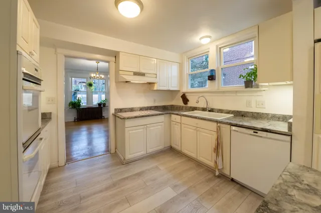 a kitchen with granite countertop a refrigerator stove top oven and sink