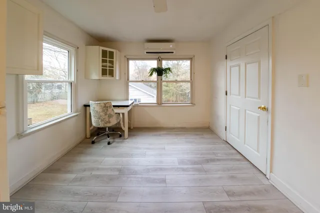 a view of a workspace with wooden floor and a window