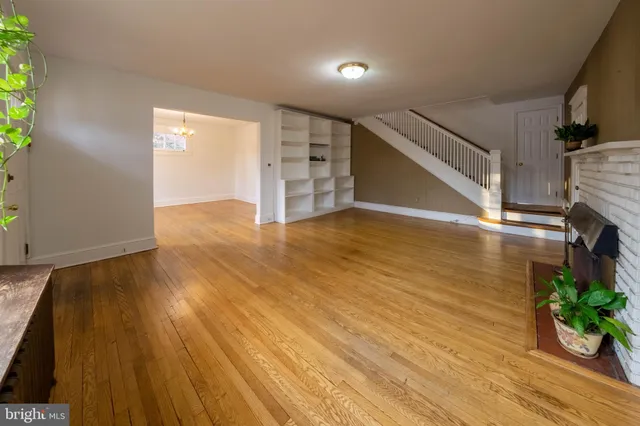 a view of empty room with wooden floor and fireplace