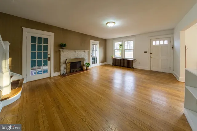 a view of empty room with wooden floor and fireplace