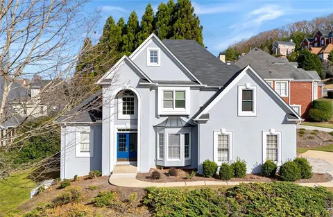 a view of a white house with a flower garden