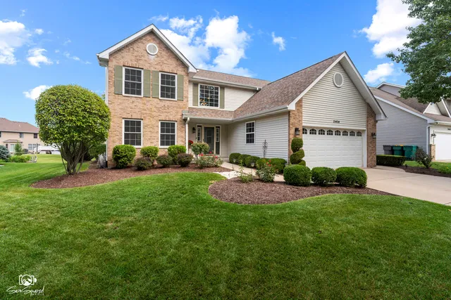 a front view of a house with a yard and garage