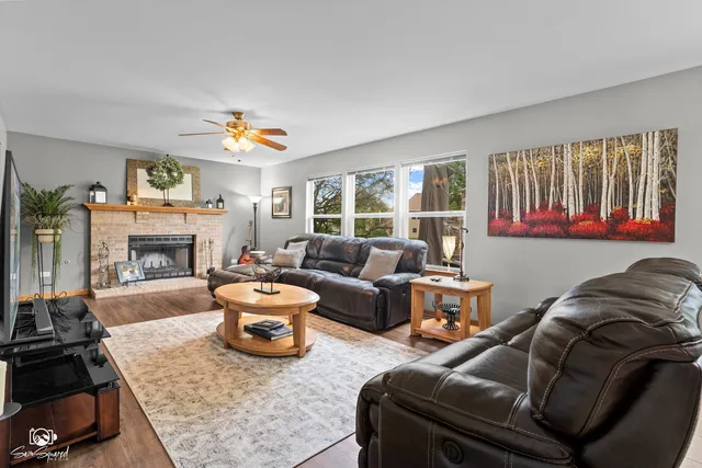 a living room with furniture a fireplace and a window
