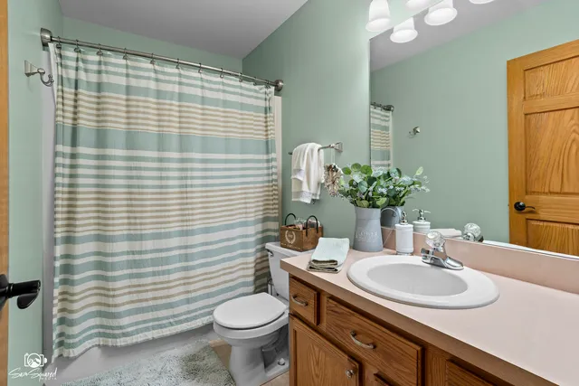 a room with pool table two couches and a dining table with wooden floor