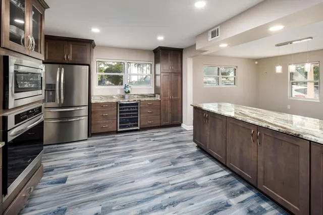 a kitchen with stainless steel appliances granite countertop a refrigerator and a stove top oven