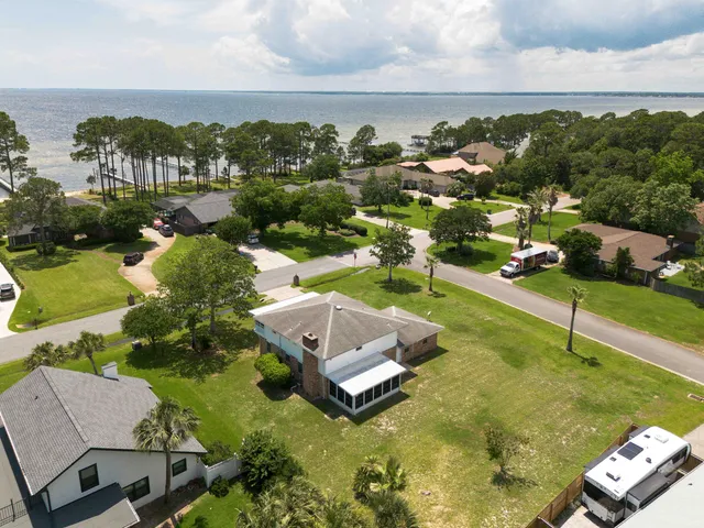 an aerial view of a house with a garden and houses