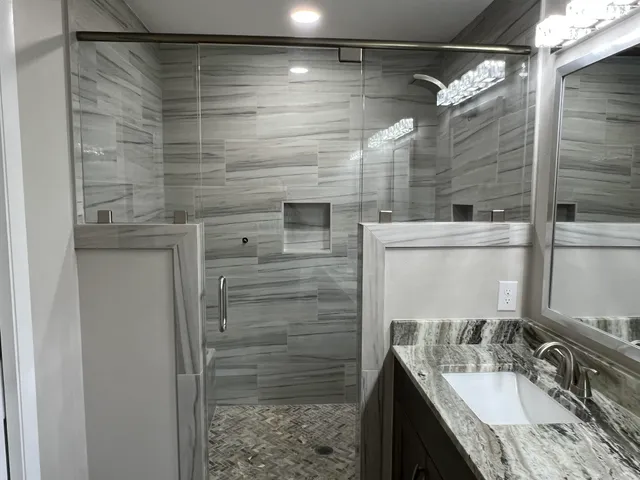 a bathroom with a granite countertop shower sink and vanity