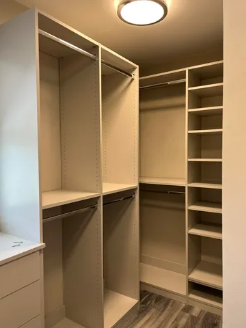 a view of walk in closet with empty racks