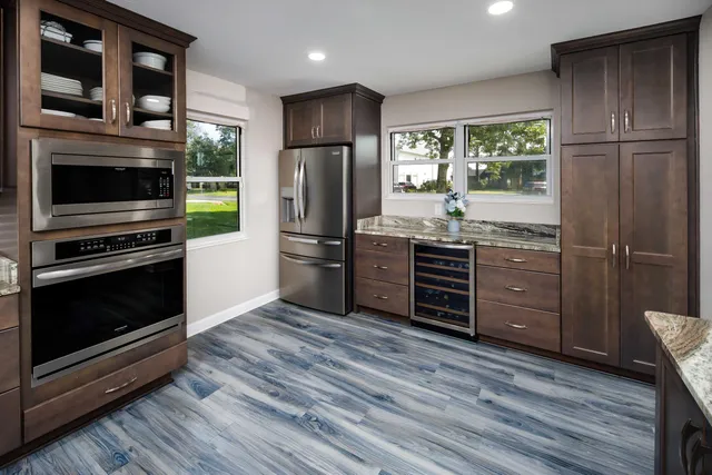a kitchen with stainless steel appliances a stove a refrigerator and a wooden floor