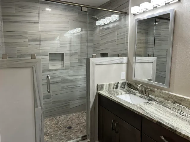 a bathroom with a granite countertop sink and mirror