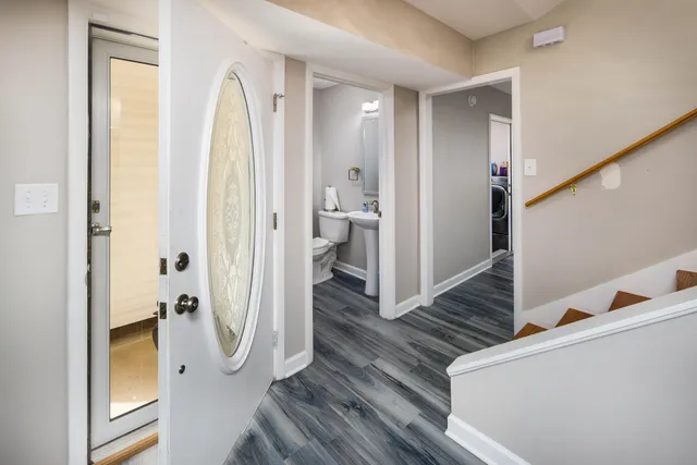 a view of a hallway with wooden floor and staircase