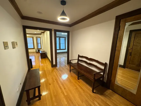 a view of a hallway with wooden floor and furniture