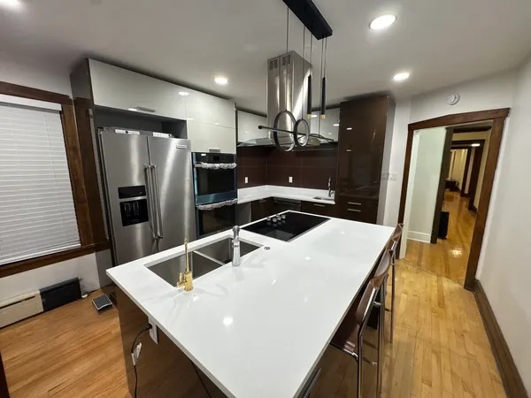 a kitchen with stainless steel appliances a refrigerator and a counter space