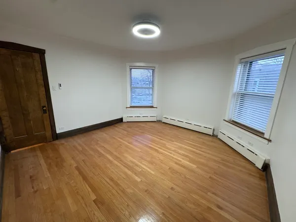 a view of room with window and wooden floor