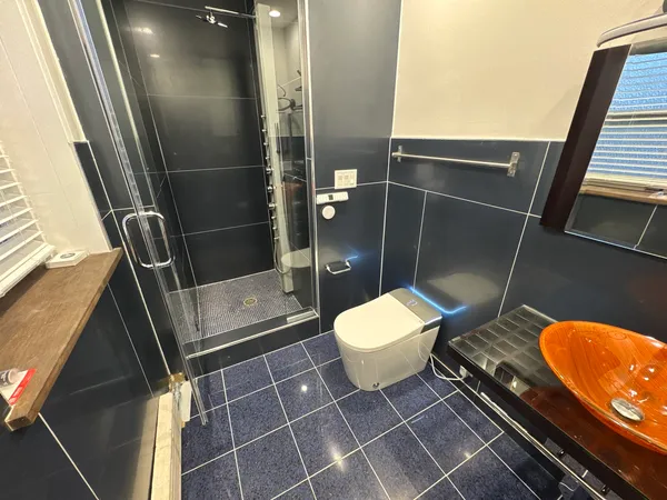 a bathroom with a toilet and a shower