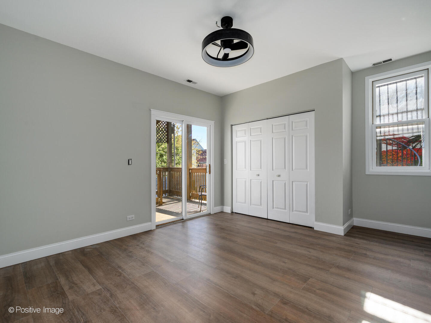 3033 North Racine Avenue, Unit 2 Chicago, IL 60657 - Photo 13 of 20 a view of an empty room with wooden floor and windows