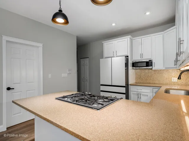 a kitchen with a refrigerator and a stove top oven
