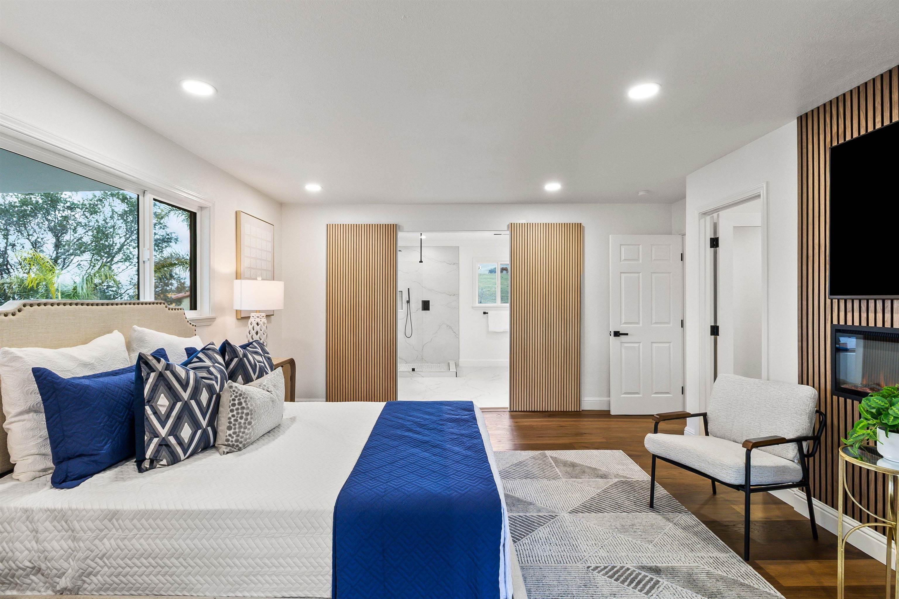 12200 Tesla Road Livermore, CA 94550 - Photo 23 of 60 a spacious bedroom with a large bed a couch and a flat screen tv