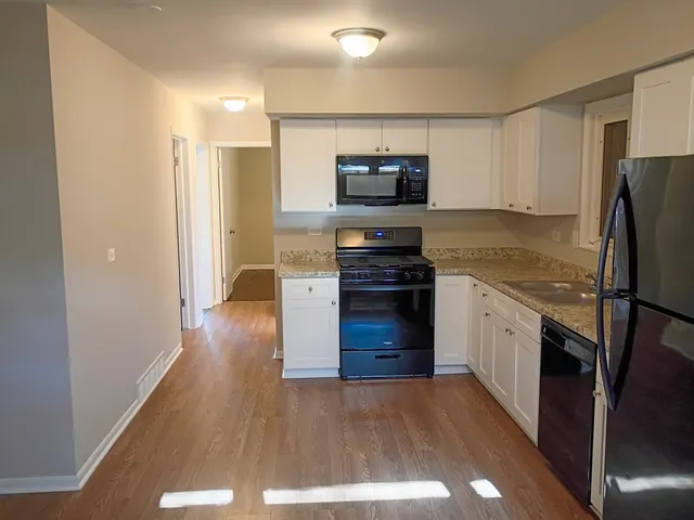 a kitchen with stainless steel appliances a stove a sink and a refrigerator