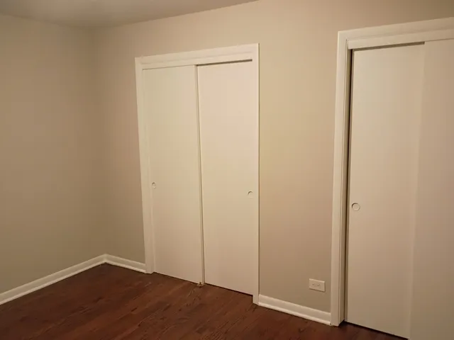 an empty room with wooden floor and closet