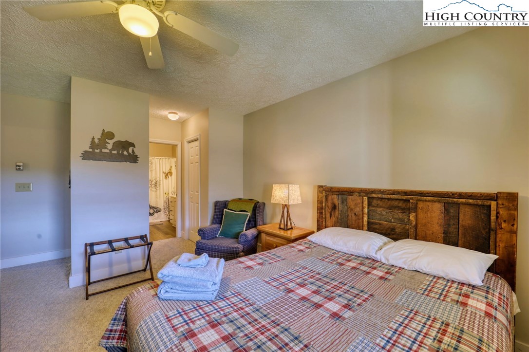 1355 7 Devils Road, Unit 302 Seven Devils, NC 28604 - Photo 22 of 44 a bedroom with a bed and lamp