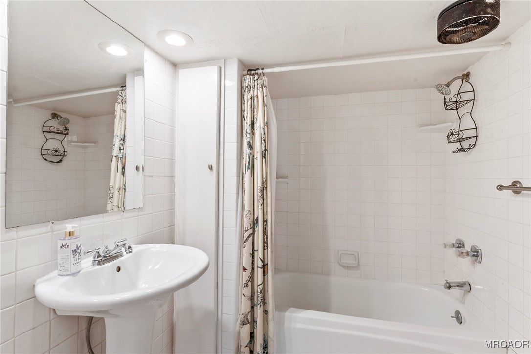 784 Sierra Vista Drive Twin Peaks, CA 92391 - Photo 11 of 17 a bathroom with a sink a mirror and a bathtub
