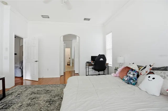 a bedroom with a bed and wooden floor