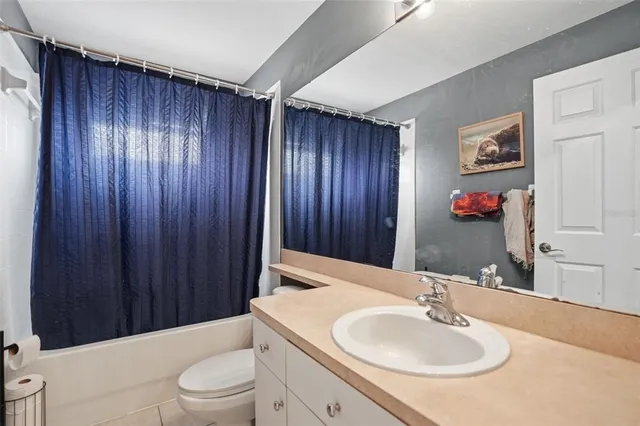 a bathroom with a sink a toilet and shower curtain