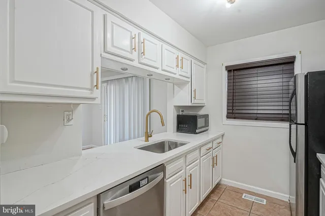 a kitchen with stainless steel appliances granite countertop a sink and a refrigerator
