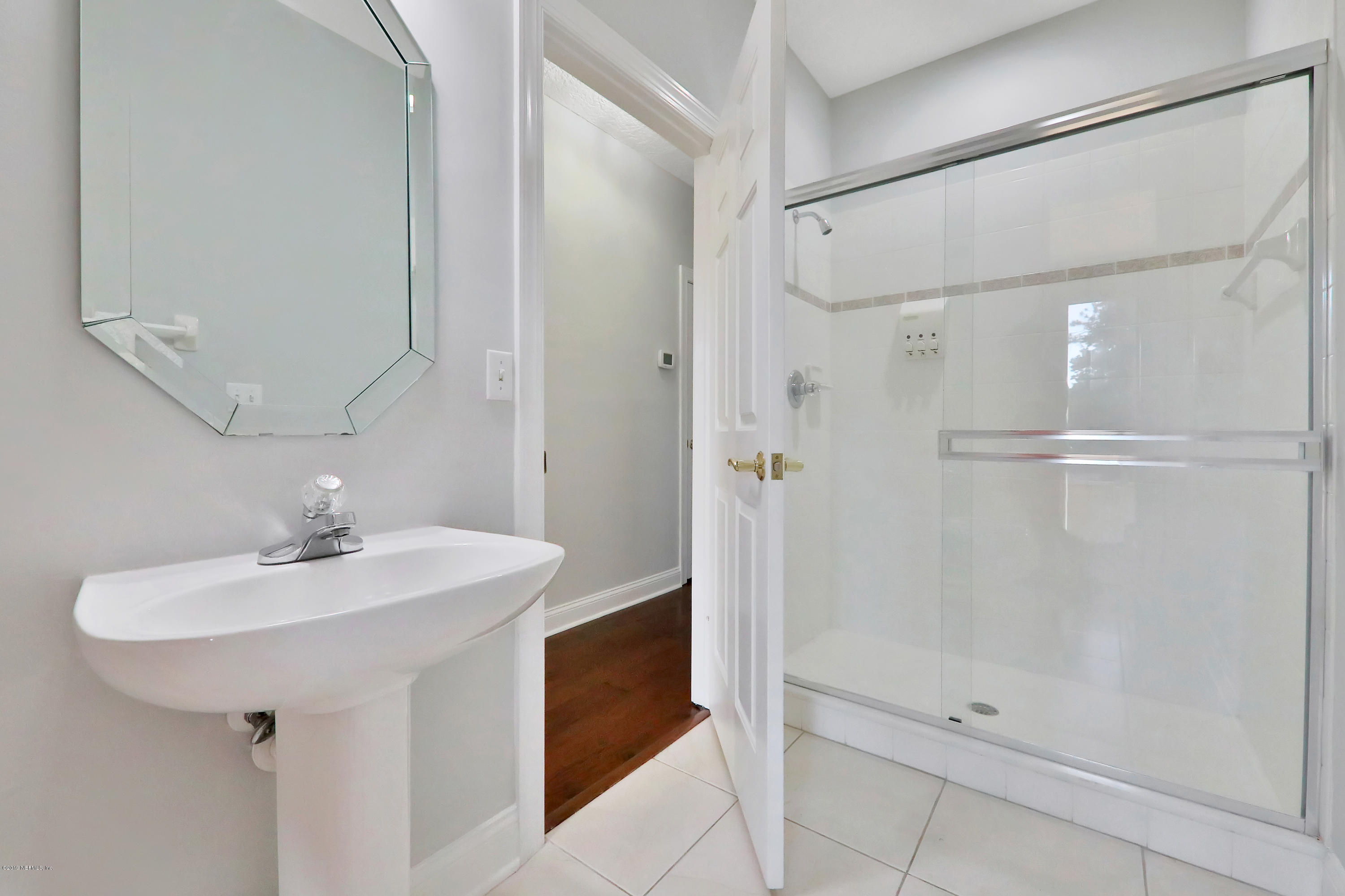 1444 Course View Drive Fleming Island, FL 32003 - Photo 25 of 61 a bathroom with a sink a mirror a shower and vanity