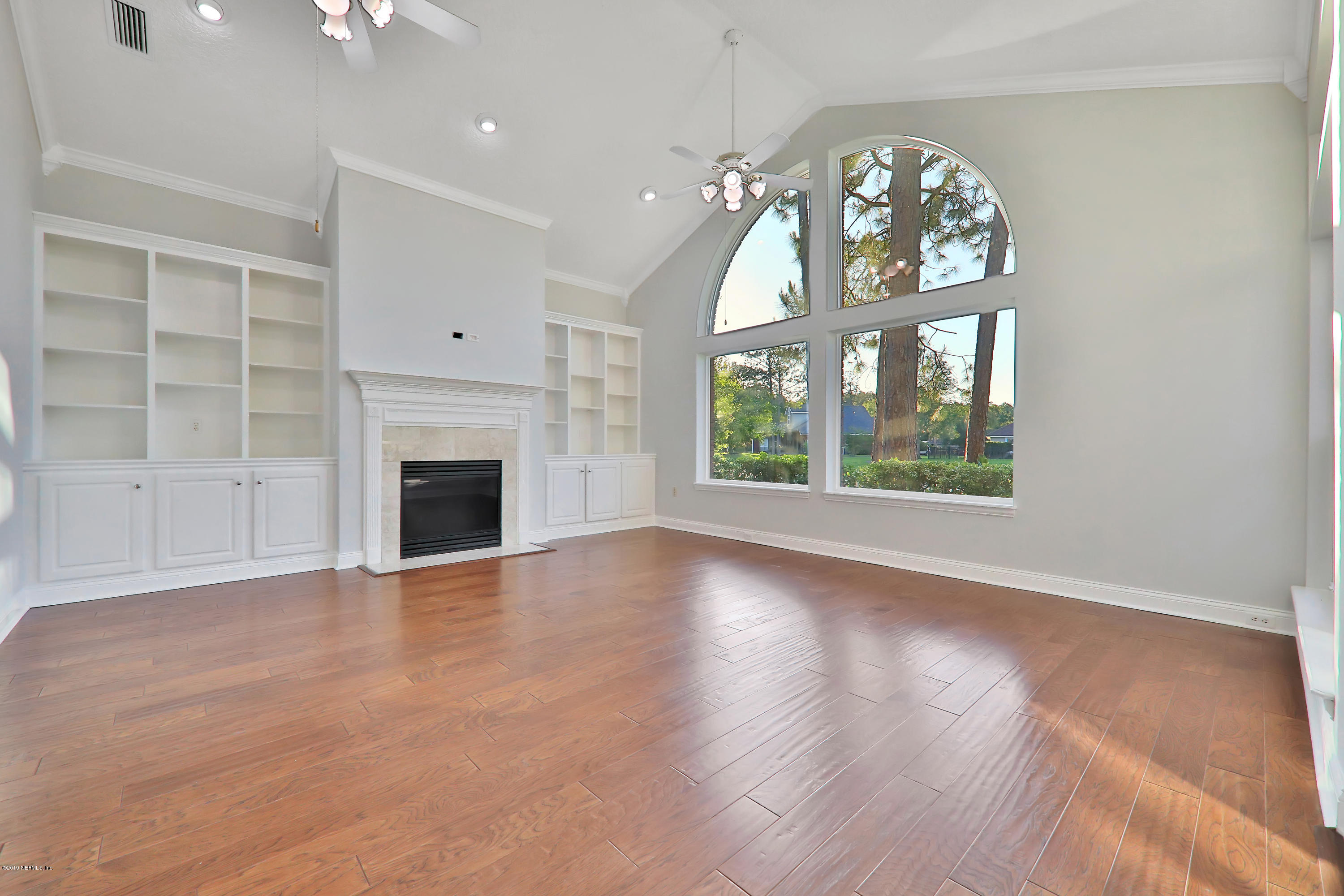 1444 Course View Drive Fleming Island, FL 32003 - Photo 30 of 61 an empty room with wooden floor fireplace and windows