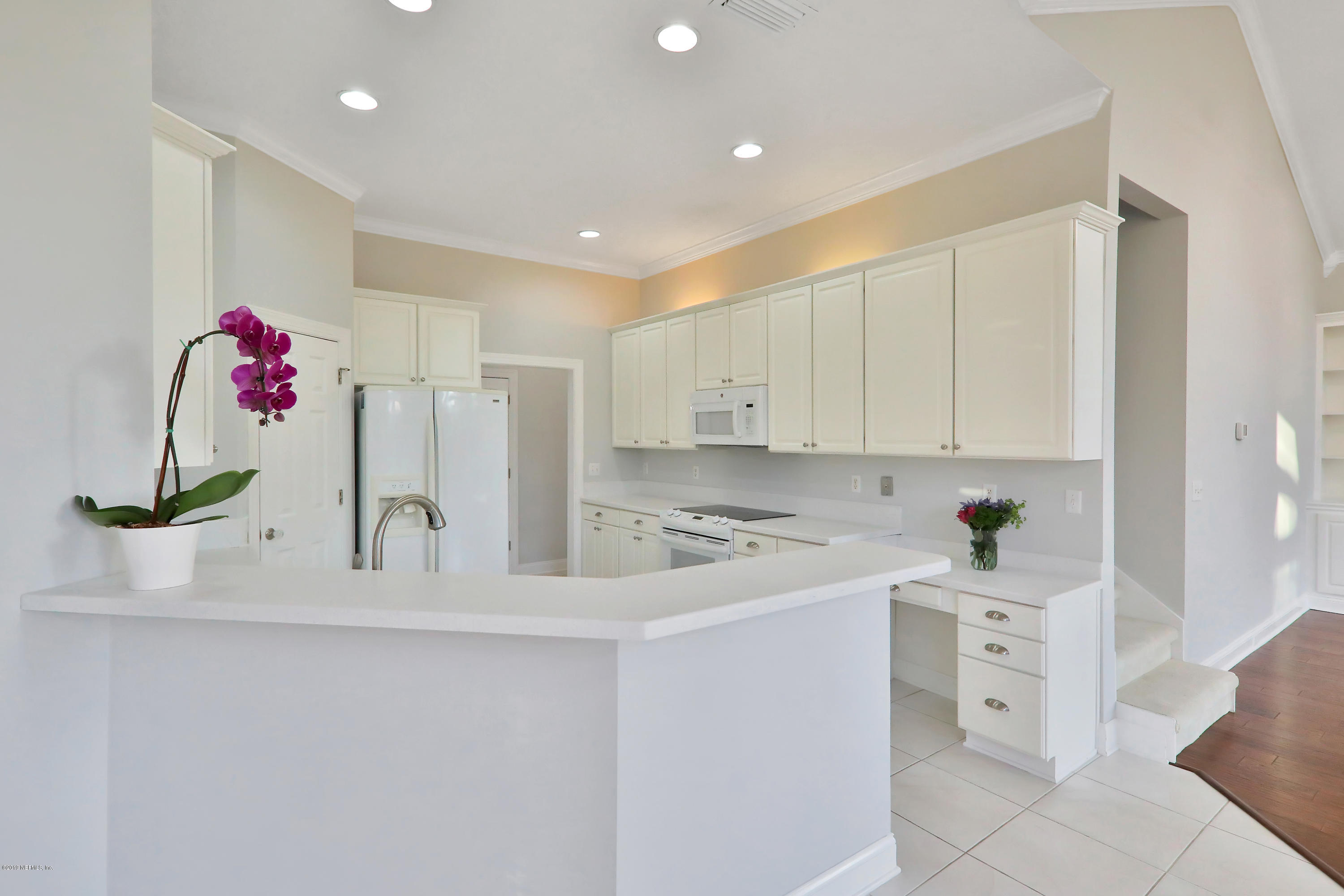 1444 Course View Drive Fleming Island, FL 32003 - Photo 35 of 61 a kitchen with white cabinets and white appliances