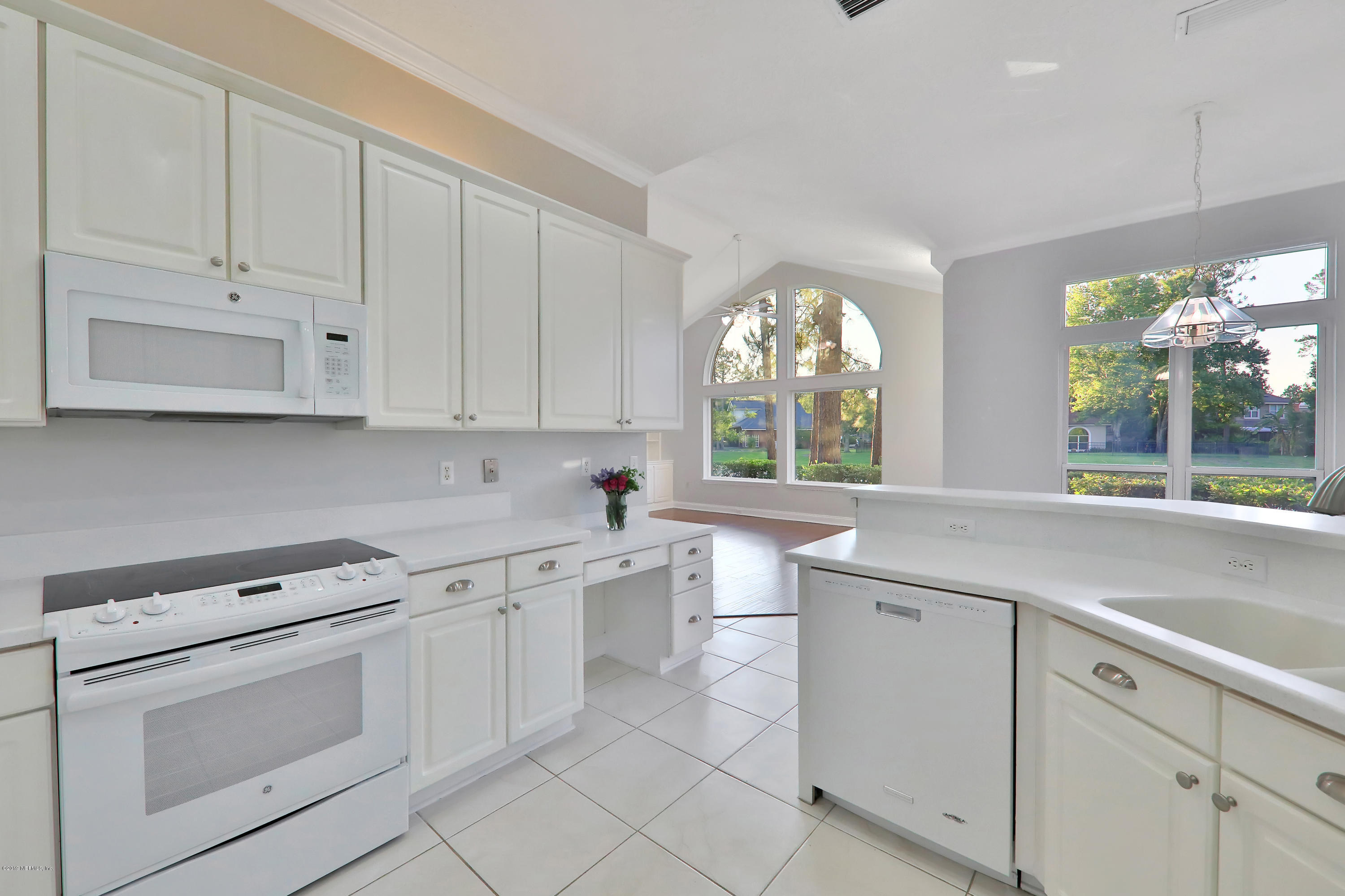 1444 Course View Drive Fleming Island, FL 32003 - Photo 38 of 61 a kitchen with white cabinets appliances a sink and a large window