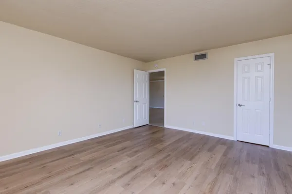 a view of an empty room with wooden floor