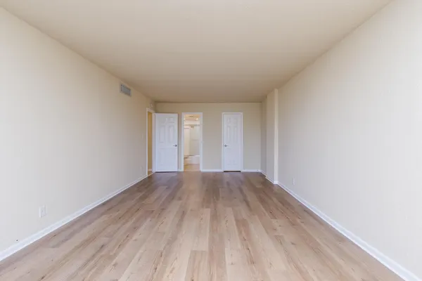 a view of an empty room and wooden floor
