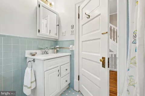 a bathroom with a bathtub sink and mirror