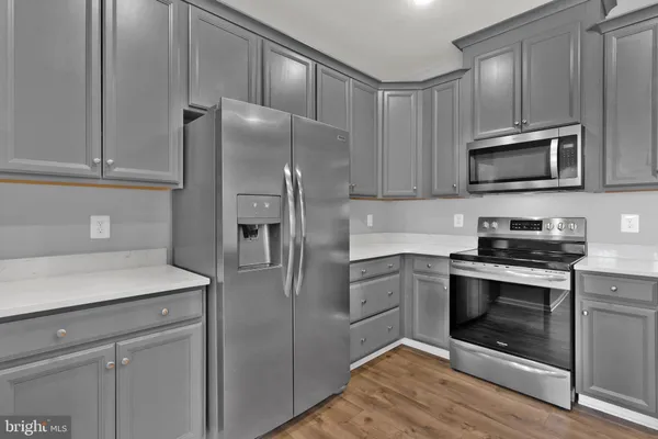a kitchen with stainless steel appliances granite countertop a stove a refrigerator and a microwave