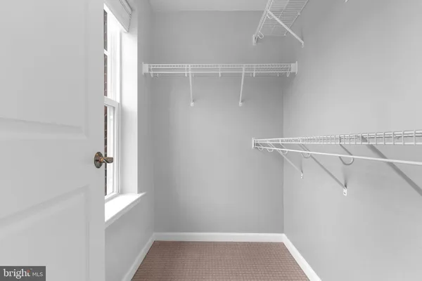 a view of walk in closet with empty racks