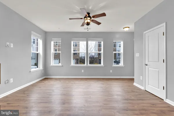 a view of an room with wooden floor and a ceiling fan