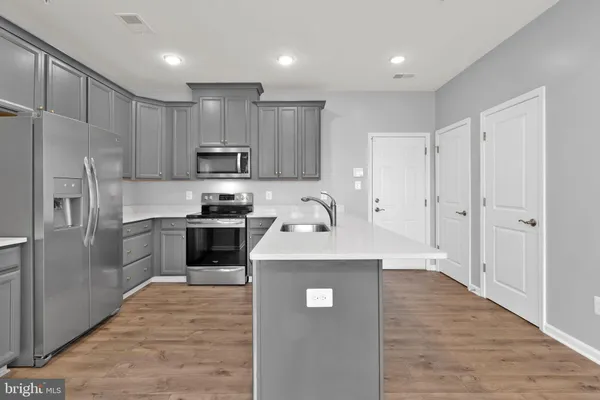 a kitchen with granite countertop a refrigerator stove top oven and sink