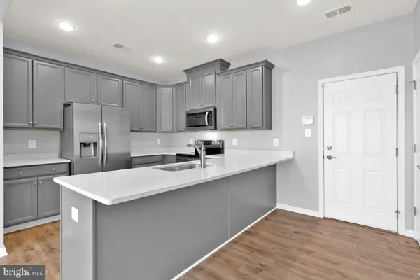 a kitchen with kitchen island a sink stainless steel appliances and cabinets