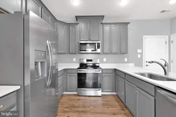 a kitchen with stainless steel appliances granite countertop a stove a sink and a refrigerator